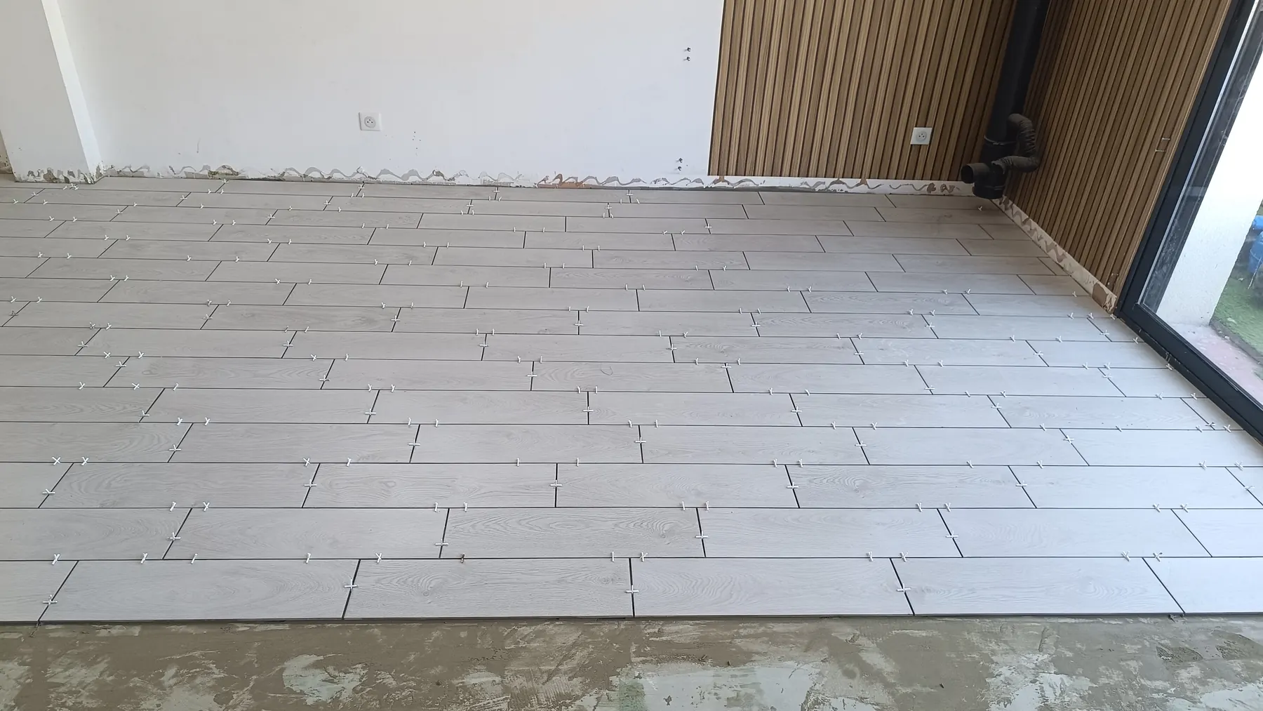 Grey wood-effect plank tiles laid in a staggered pattern