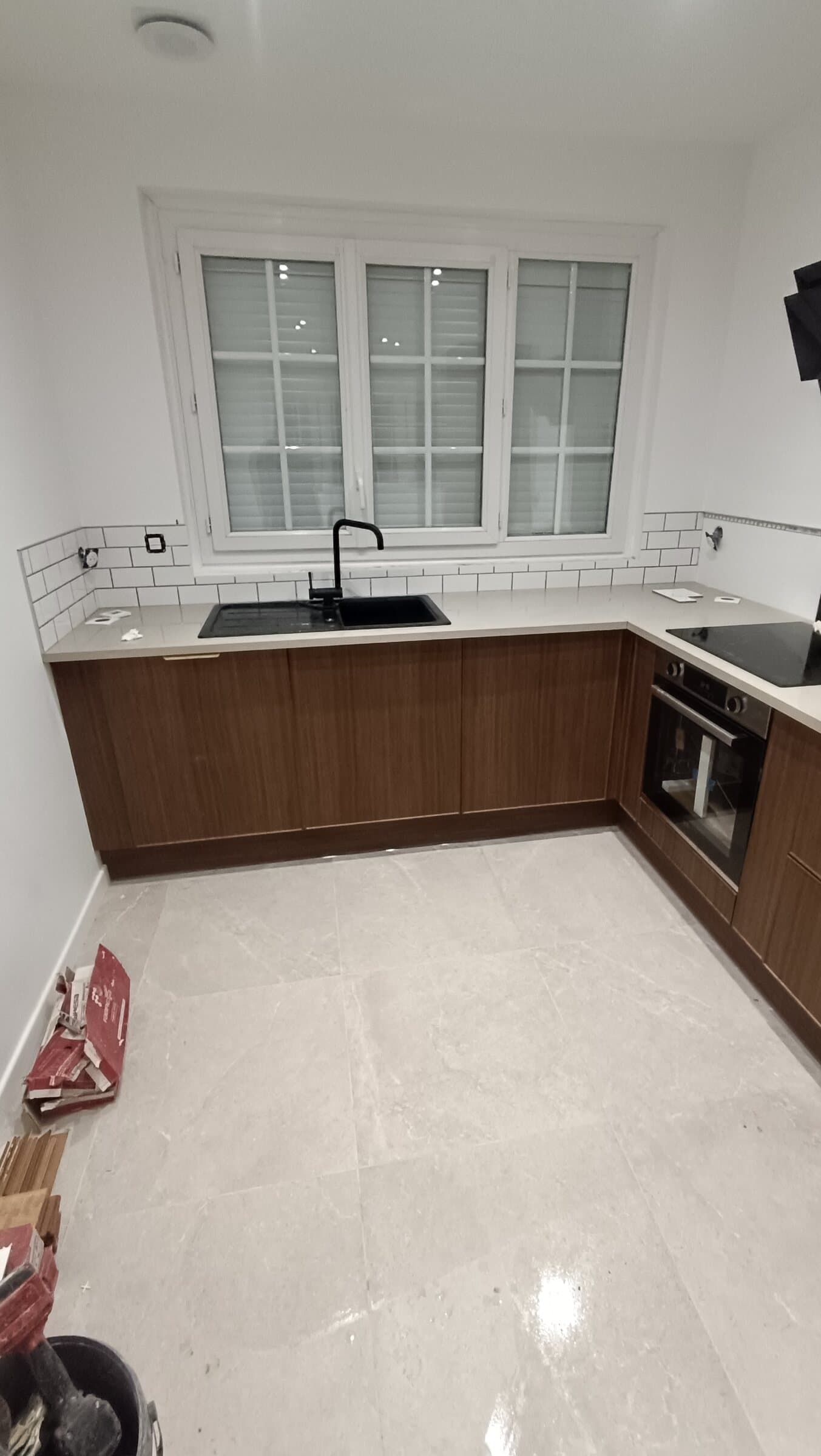 Cuisine avec crédence en carrelage métro blanc et sol en grands carreaux clairs