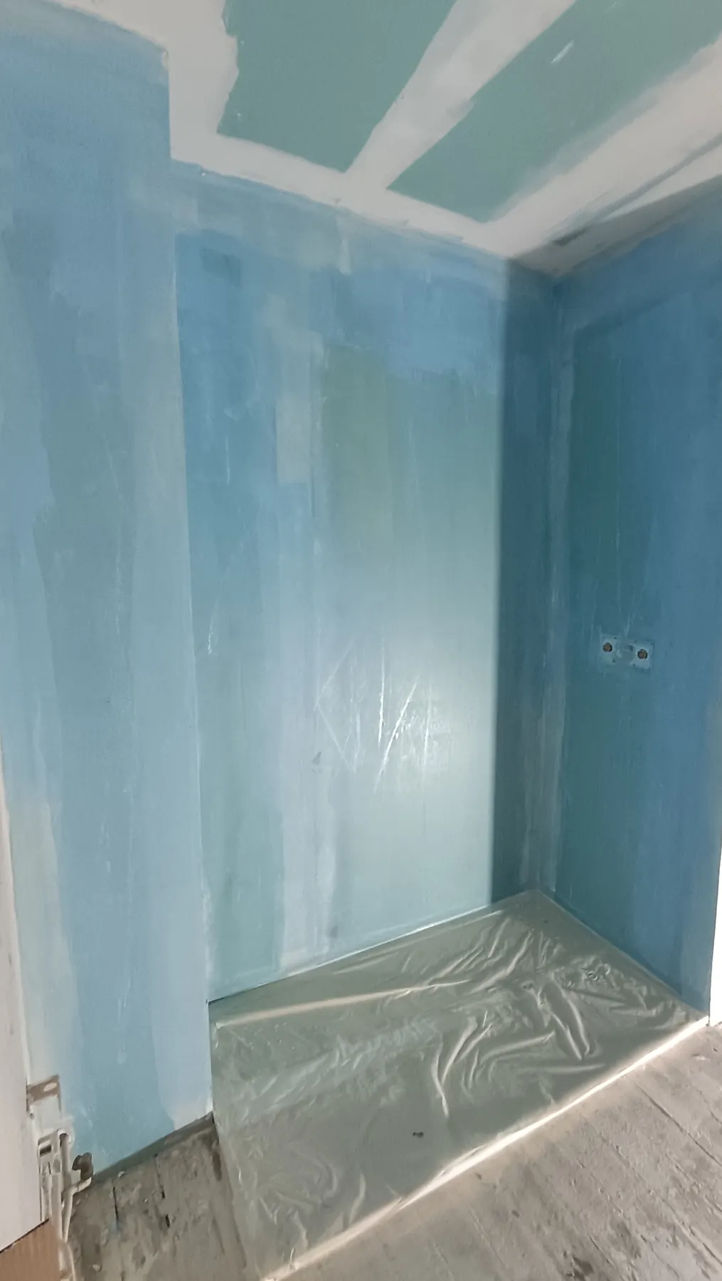 Protection à l’eau sous carrelage appliquée sur les murs d’une douche