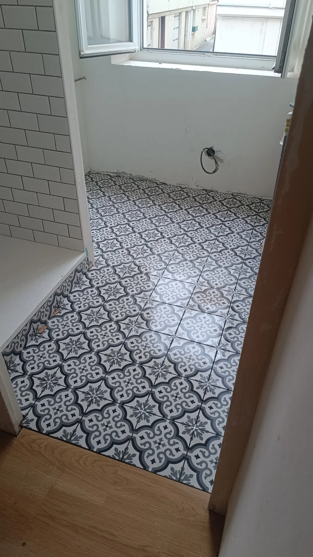 Bathroom in white metro tiles with a black and white cement-tile floor