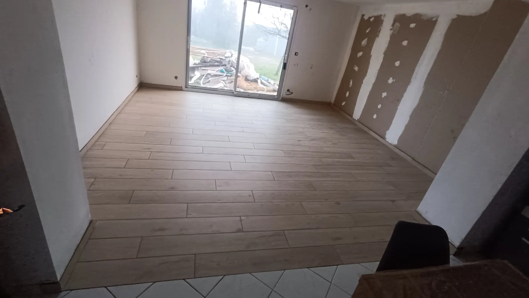 Living room in light wood-effect tiles opening onto the garden
